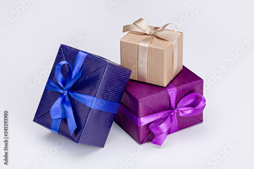 Gifts in multi-colored festive packaging, with ribbons and bows. White background, copy space.