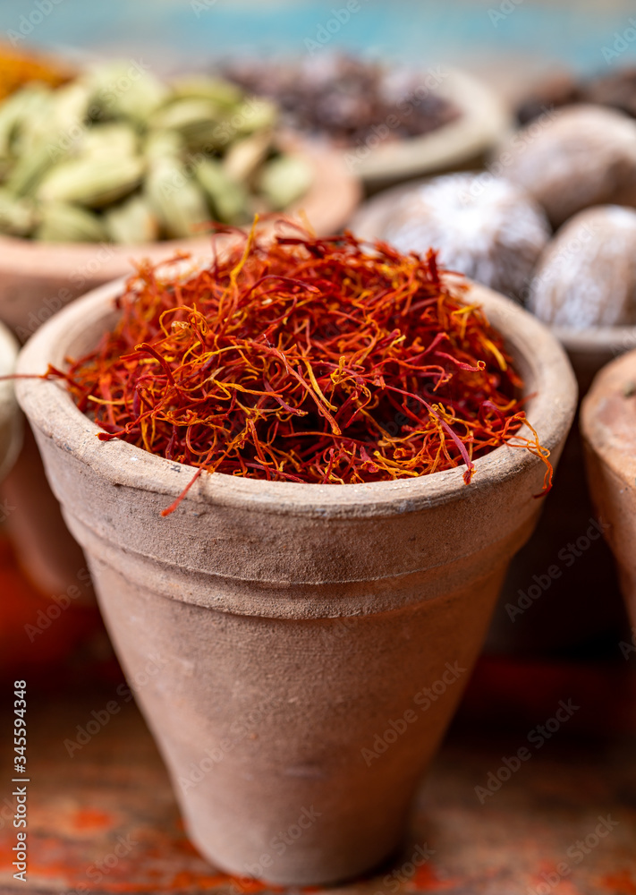 Fototapeta premium Indian spices collection, dried red saffron and another spices in clay bowls