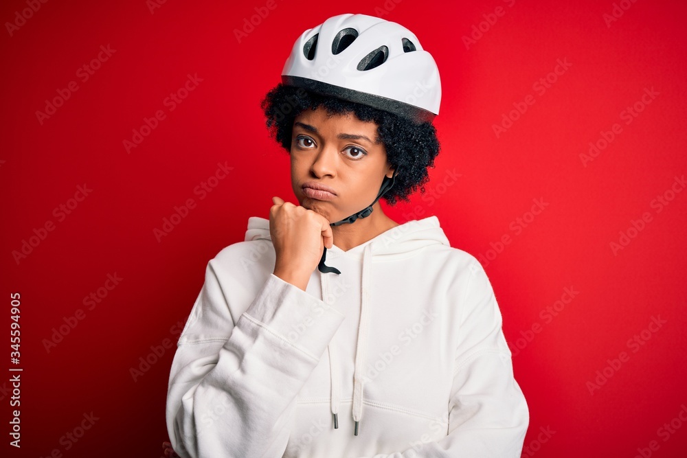 Young African American afro cyciling woman with curly hair wearing bike security helmet thinking looking tired and bored with depression problems with crossed arms. Young African American afro cyciling woman with curly hair wearing bike security helmet thinking looking tired and bored with depression problems with crossed arms.