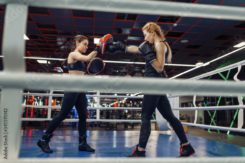 Two women boxing on the ring, box workout