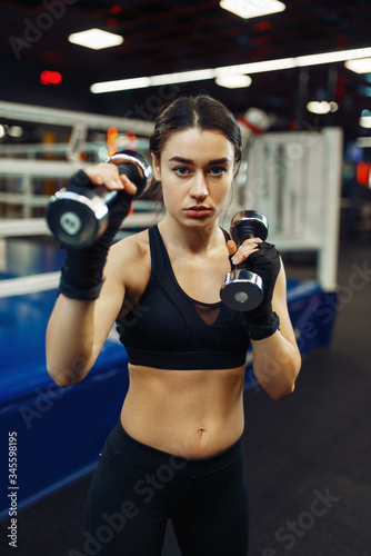 Woman doing exercise with dumbbells, box training