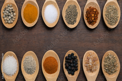Various spices in wooden spoon on wood table background
