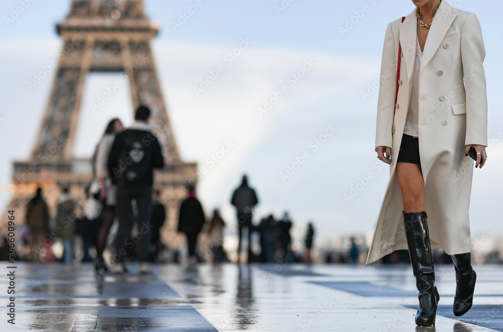 Obraz premium Street style outfit – Woman wearing an ivory coat and black knee high leather high heel boots – StreetStyleFW2020