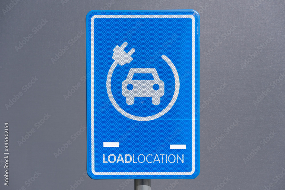 electrical charging station sign conveniently located next to a public parking lot electrical charging station sign conveniently located next to a public parking lot