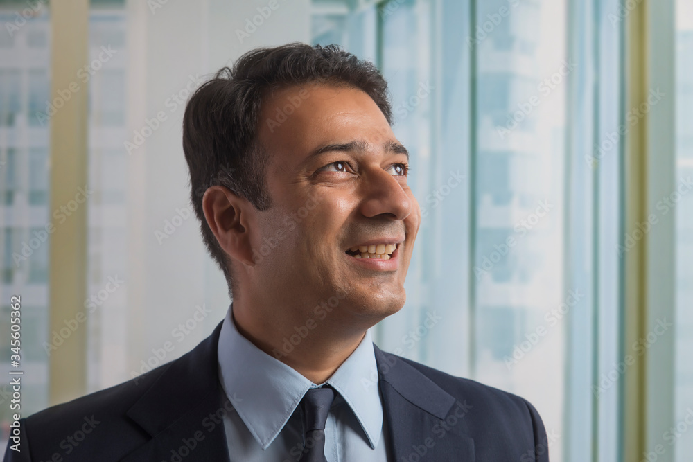Close up of a smiling businessman in office looking away
Close up of a smiling businessman in office looking away