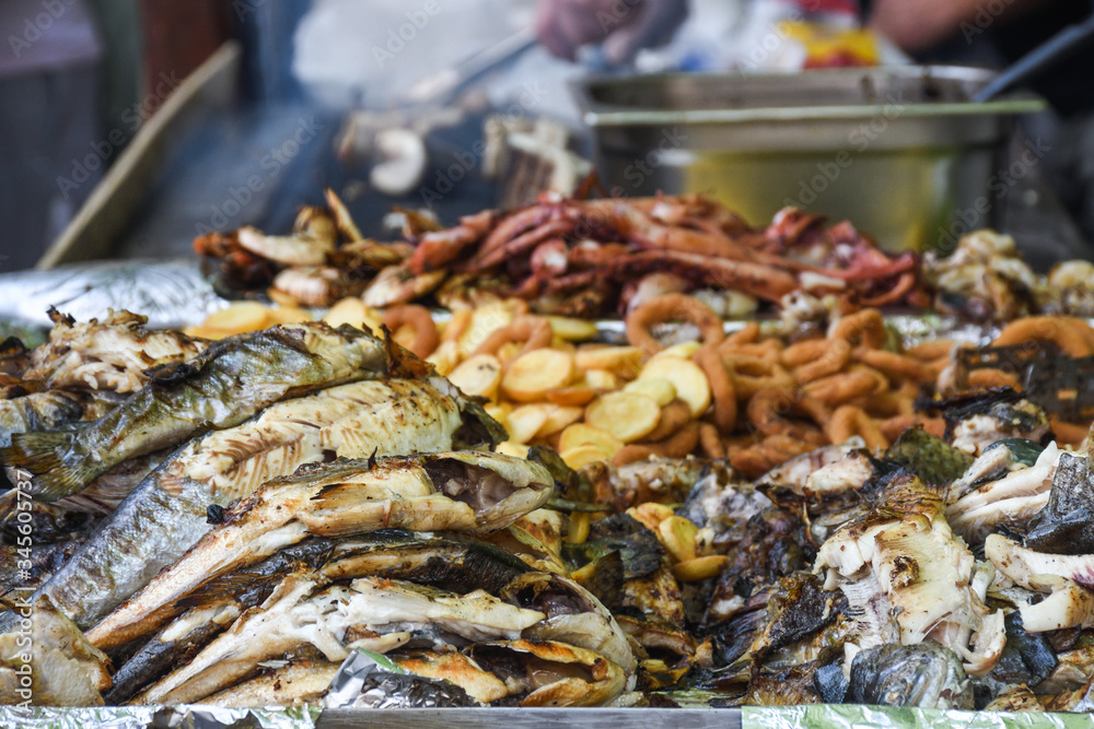 Freshly grilled fish on counter top stall, during seafood festival, street food market.