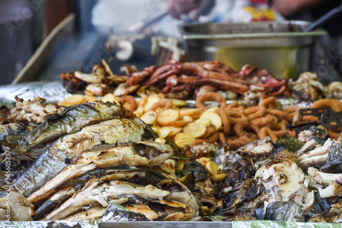 Freshly grilled fish on counter top stall, during seafood festival, street food market.