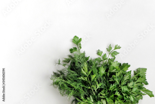A large bunch of fresh organic green parsley  dill on a white background. Garden greens  spicy herbs  ingredients for cooking. Close-up  top view with copy space for text.