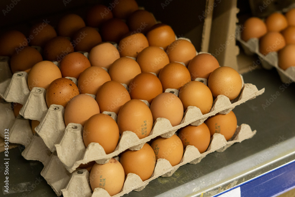 Fresh chicken brown eggs in a cardboard egg tray on a shelf in a store Fresh chicken brown eggs in a cardboard egg tray on a shelf in a store