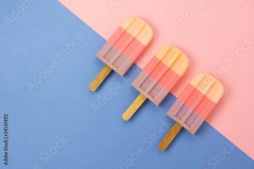 Table top view aerial image of sign or food of summer season holiday background concept.Flat lay of pastel ice cream on modern rustic blue sea paper and pink backdrop.Minimalism design. copy space.
