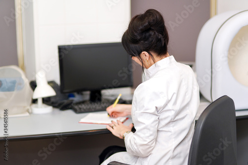 Female Doctor's working on laptop computer, writing prescription notepad with record information on desk in hospital or clinic, Healthcare and medical concept © alenaphoto
