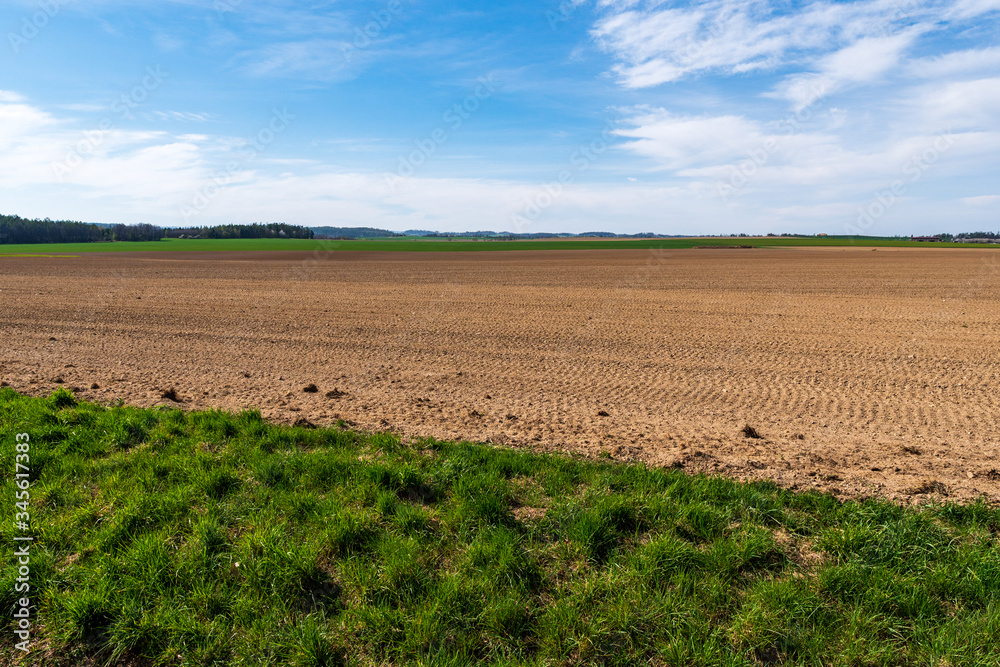 Agricultural field,brown soil farm landscape, Arable land, sow field in spring with beautiful sky on a sunny day