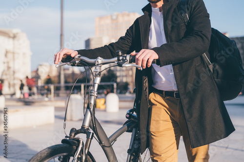 Unrecognizable professional young caucasian man outdoor using bike