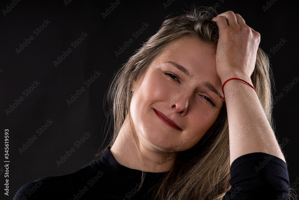 portrait of a young sad crying girl on a black background portrait of a young sad crying girl on a black background