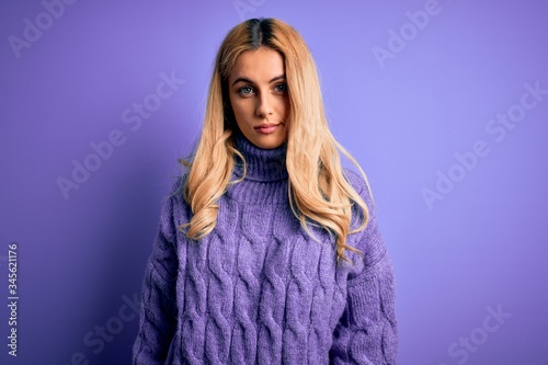 Young beautiful blonde woman wearing casual turtleneck sweater over purple background looking sleepy and tired, exhausted for fatigue and hangover, lazy eyes in the morning.