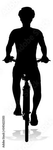 Bicyclist riding their bike and wearing a safety helmet in silhouette