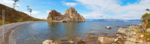 Baikal Lake. Panoramic view of the natural landmark of the island of Olkhon - the rock Shamanka from the pebble beach. Wide banner, natural background, beautiful landscape