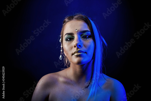 ethnic girl on a black background in blue light
