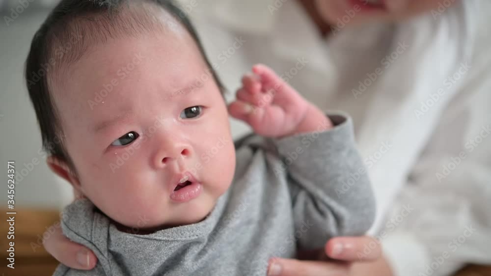 Asian woman holding a newborn baby in her arms at home.Mother day and newborn baby infant health care concept. Asian woman holding a newborn baby in her arms at home.Mother day and newborn baby infant health care concept.