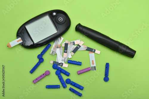 1 Diabetes set with glucometer, lancet, spare needles on green background 