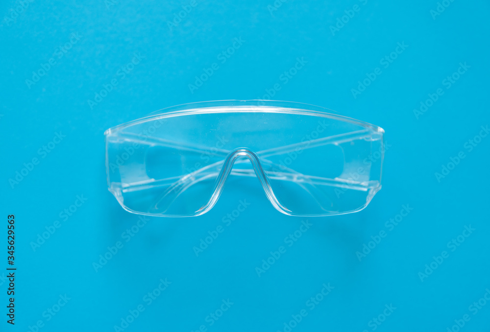 Protective glasses lying on a blue background. Protective glasses lying on a blue background.