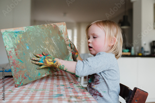 niedliches kleines Kind malt mit bunter Fingerfarbe Kindergartenkind Tusche Wasserfarben bunt und wild photo