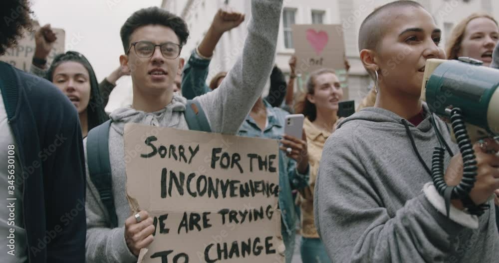 Group of young people protesting with banners and megaphone