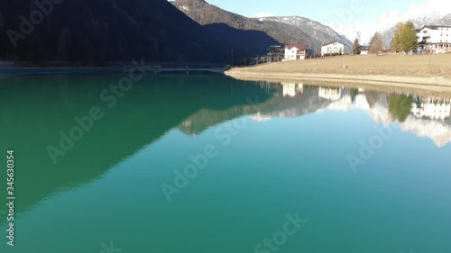 Aerial footage flying above lake in alpine village