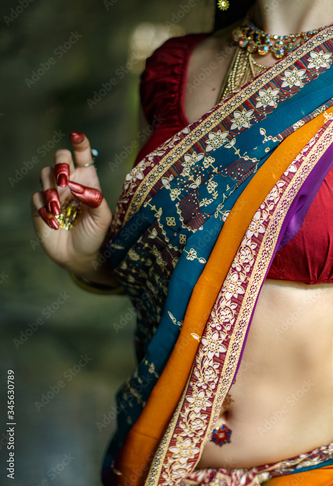 Indian girl in national dress, belly and hand with traditional painting.
