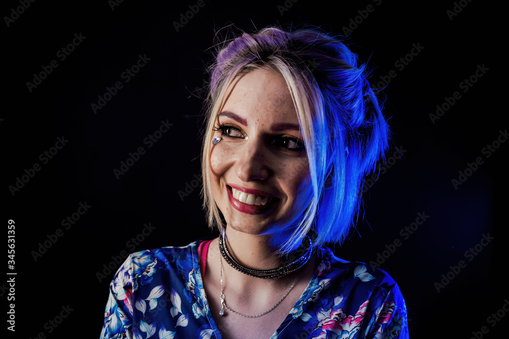 Infantile girl on a black background in blue light Infantile girl on a black background in blue light