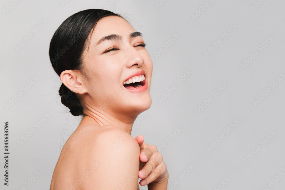 young beautiful asian woman with clean and bright skin, Cosmetic Beauty Concept,looking,smiling and friendly face isolated on grey background young beautiful asian woman with clean and bright skin, Cosmetic Beauty Concept,looking,smiling and friendly face isolated on grey background