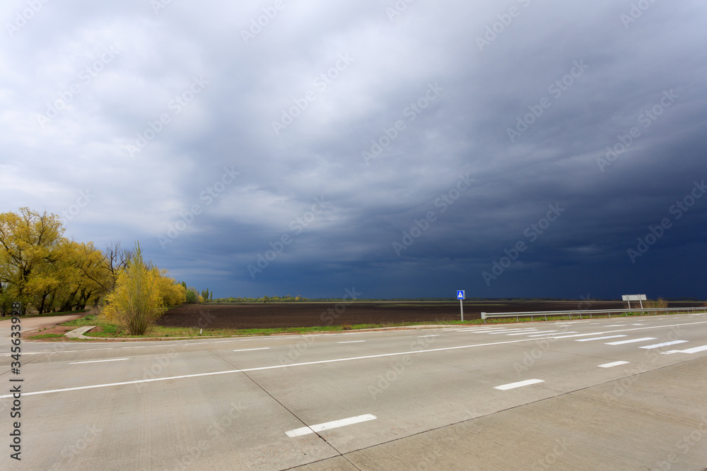 Fototapeta premium thunderclouds over an asphalt road