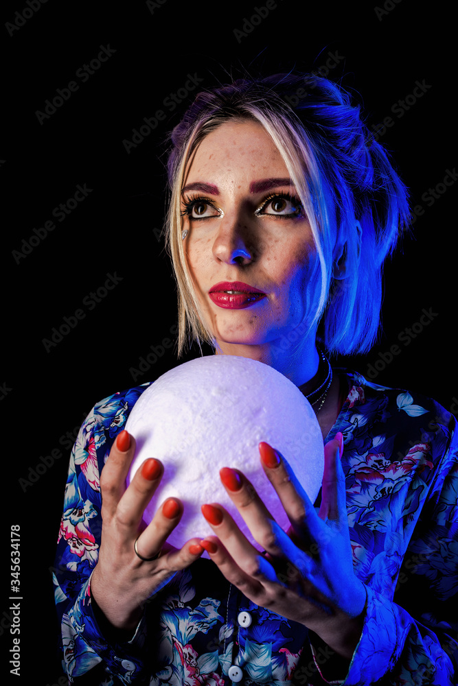 Naklejka premium Infantile girl on a black background in blue light