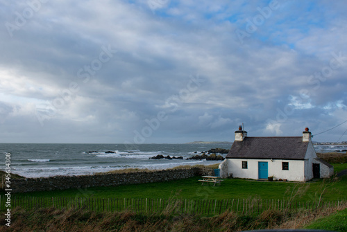 Fotografija A remote isolated, traditional, country cottage by a windswept beach on a winters day