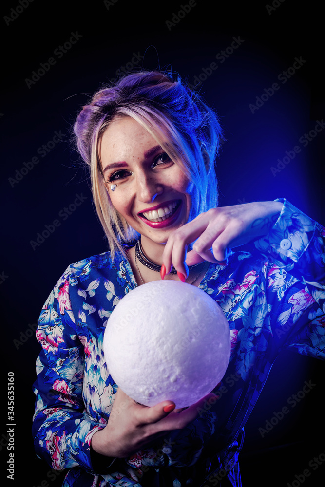 Naklejka premium Infantile girl on a black background in blue light