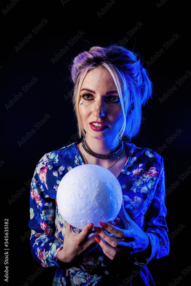 Naklejka premium Infantile girl on a black background in blue light