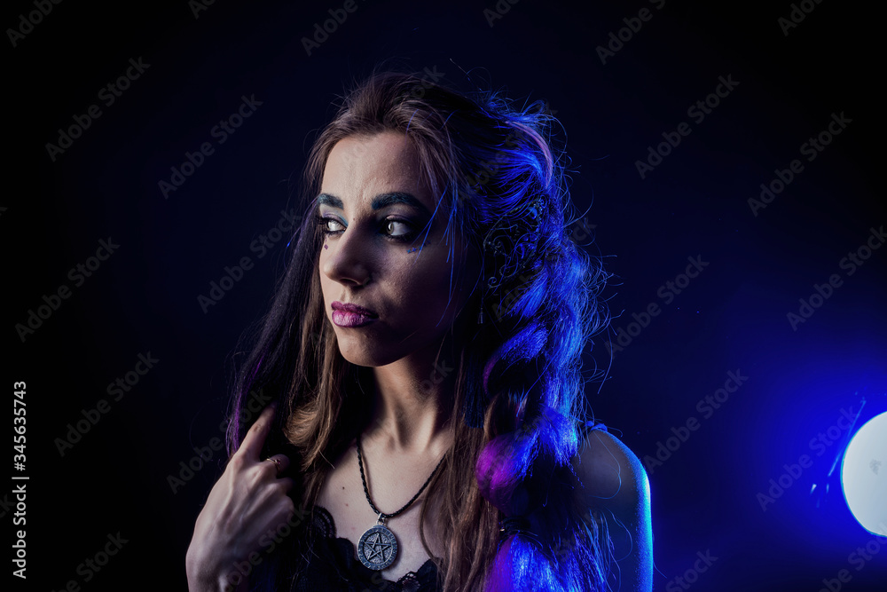 Girl in werewolf style on a black background with blue light Girl in werewolf style on a black background with blue light