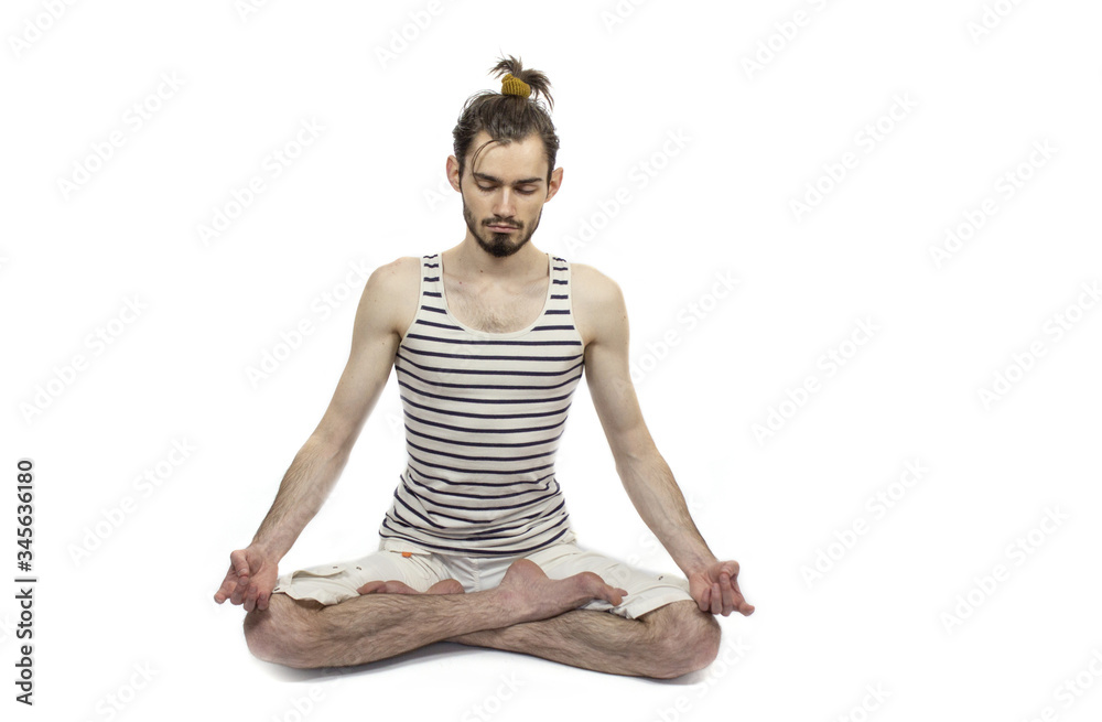 Yoga guy with closed eyes sits in lotus position. White background in the studio. Meditation. Stress relief. Copyspace