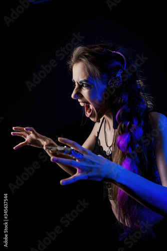 Girl in werewolf style on a black background with blue light