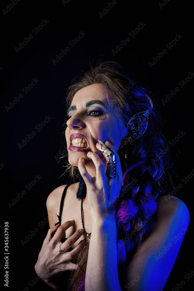 Girl in werewolf style on a black background with blue light Girl in werewolf style on a black background with blue light