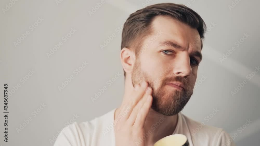 closeup of a handsome young man concludes his beard closeup of a handsome young man concludes his beard