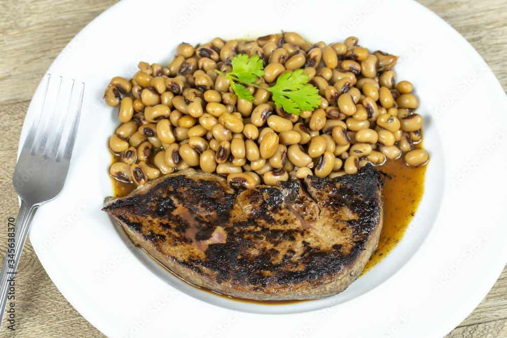 foie de veau grillé et haricot oeil noir cuit dans une assiette foie de veau grillé et haricot oeil noir cuit dans une assiette