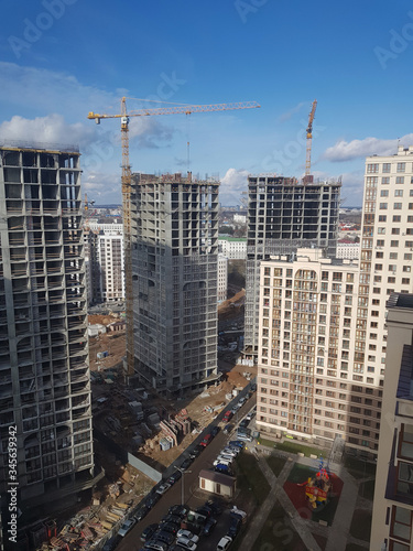 Close-up of construction site. Building new luxury complex for living. High cranes for heavy load. All necessary equipment for builders. Bricks sand and other stuff