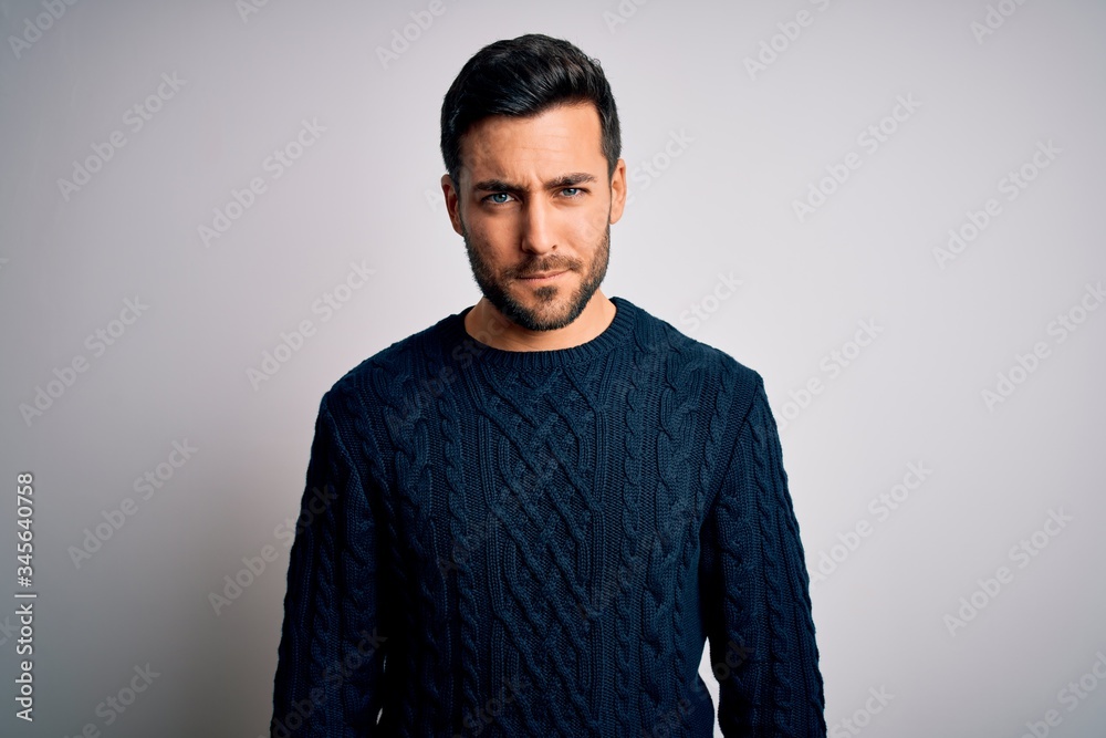 Fototapeta premium Young handsome man with beard wearing casual sweater standing over white background skeptic and nervous, frowning upset because of problem. Negative person.