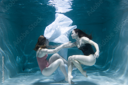 Two beautiful lesbian girls are swimming underwater. Attractiveness. Sexual poses and gestures. Female dance underwater. Swimwear and pool. Two mermaids. Two girlfriends women.Gay girls. Same-sex love © Underwater girls