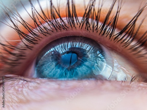 caucasian human blue eye in a contact lens looking up close up. contact lens vision medical correction concept