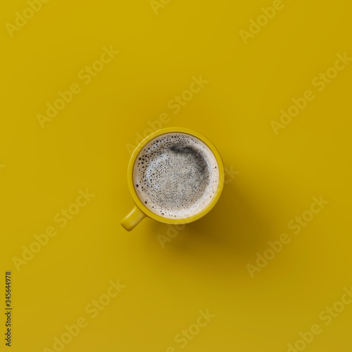 Yellow cup of coffee isolated on a yellow background. View from above