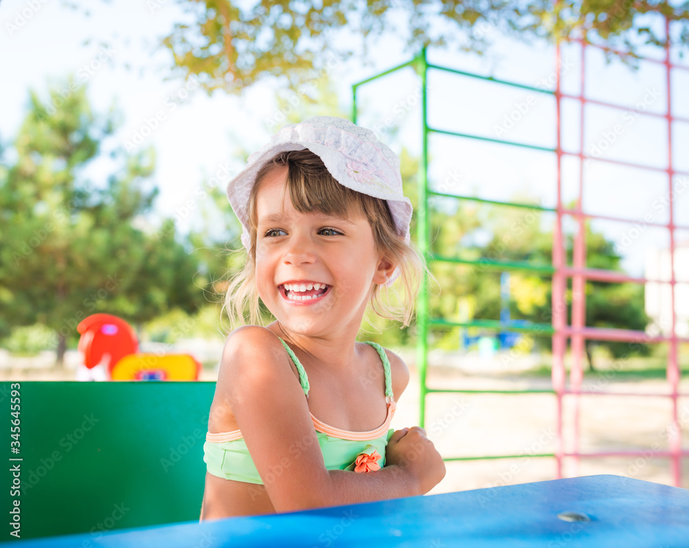 Little cute girl playing dolls outdoors while relaxing on the beach on a hot summer day. The concept of active games for children. Little cute girl playing dolls outdoors while relaxing on the beach on a hot summer day. The concept of active games for children.