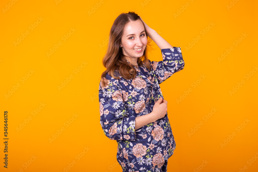 Cute and cheerful woman in home wear pajama studio lifestyle yellow background emotions. Cute and cheerful woman in home wear pajama studio lifestyle yellow background emotions.