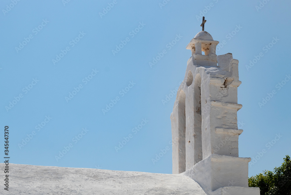 A beautiful white painted chapel at the peaceful Greek island of Folegandros. A view of the bell tower and the arched, roof. Classical cycladic architecture. The building is lit by the evening sunshin A beautiful white painted chapel at the peaceful Greek island of Folegandros. A view of the bell tower and the arched, roof. Classical cycladic architecture. The building is lit by the evening sunshin